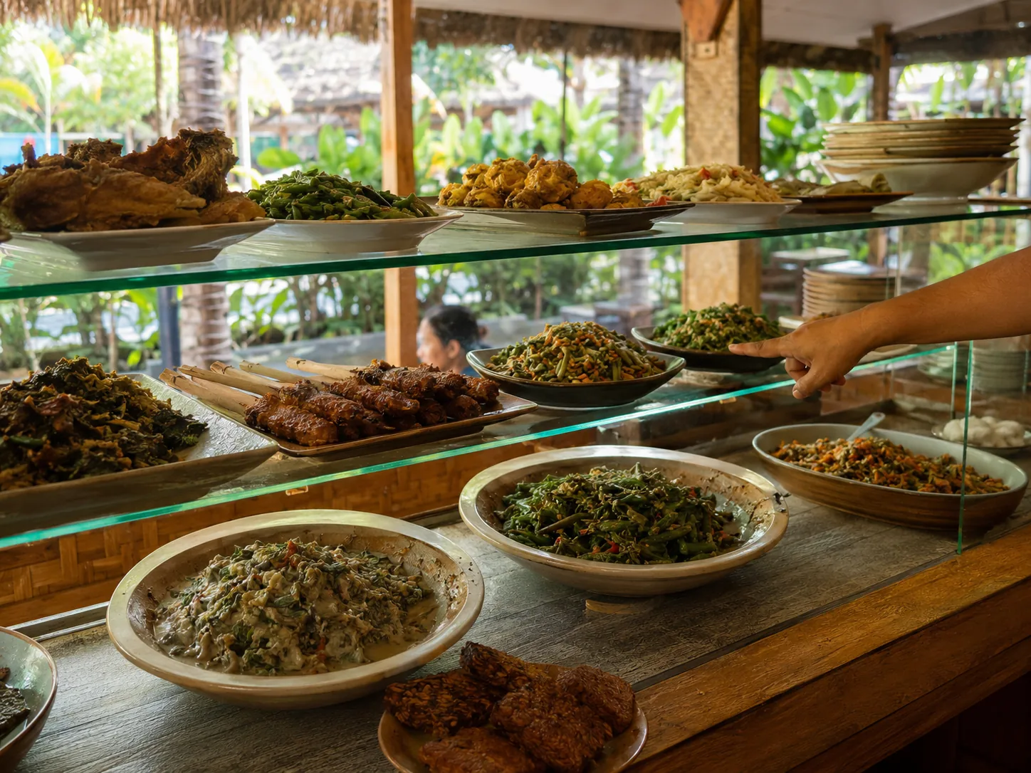 A traditional Balinese warung counter with a spread of nasi campur side dishes on a teak table